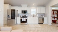 Located at 1009 Big Constellation Way in San Marcos, TX, this thoughtfully designed single-story home offers two bedrooms and one bathroom across a well-utilized floor plan. The open-concept layout seamlessly connects the living area to a fully equipped kitchen, which features white shaker-style cabinetry with crown molding detail, light countertops, a full suite of stainless steel appliances, and a window above the sink that brings in natural light. The living space flows naturally from the kitchen, creating a cohesive and functional common area. The primary bedroom is a comfortable retreat with crown molding, a ceiling fan, multiple windows for natural light, and a closet. The second bedroom mirrors this bright, airy character, featuring additional windows, crown molding, and its own closet, making it equally suitable as a guest room or home office. The shared bathroom is efficiently designed with tile flooring, a vanity with ample storage, a toilet, and a glass-enclosed walk-in shower with tile surround and a window for ventilation. Neutral tones, light-toned flooring, and recessed lighting carry throughout the home, creating a clean, consistent aesthetic. This home offers a practical and comfortable layout well-suited for everyday living in the heart of San Marcos.