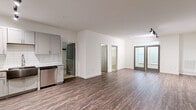 This well-appointed 3-bedroom, 3-bathroom single-floor residence at 121 Garner Rd in Spartanburg, SC offers a thoughtfully designed open-concept layout. The kitchen is a standout feature, showcasing gray shaker-style cabinetry, granite countertops, a white subway tile backsplash, a farmhouse-style stainless steel sink, and a full suite of stainless steel appliances including a range, microwave, and dishwasher. Track lighting illuminates both the kitchen and adjoining living area, which flows seamlessly into the dining room. Rich wood-look flooring extends throughout the main living spaces, lending warmth and continuity. French doors with transom windows open to an exterior space, filling the living area with natural light. The three bedrooms are carpeted for comfort, with the generously sized primary bedroom featuring multiple windows with blinds and a ceiling fan. Each bedroom benefits from its own dedicated closet with built-in wire shelving systems for organized storage. The three bathrooms are consistently finished with gray vanity cabinetry, granite countertops, lighted mirrors, and tub-shower combinations. The clean, neutral palette and modern finishes throughout create a cohesive and move-in-ready living environment.