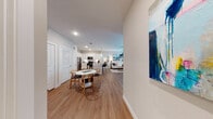 This single-floor residence offers a thoughtfully designed open-concept layout that seamlessly connects the main living areas. The kitchen is a standout feature, outfitted with crisp white shaker cabinets, granite countertops, a deep undermount sink, and a full suite of stainless steel appliances including a refrigerator, electric range, and built-in microwave. A peninsula with additional counter seating provides both prep space and a casual dining option. Wood-look flooring runs throughout the main living areas, lending warmth and visual continuity.

The living room is bright and welcoming, benefiting from multiple windows dressed with blinds and sheer curtains that allow generous natural light. A ceiling fan adds comfort, while a glass-panel door provides additional light and access. The dining area sits adjacent to the kitchen, accommodating a full dining set with ease.

The bedrooms are carpeted for comfort and feature natural light from well-positioned windows. Each bedroom includes access to a walk-in closet with built-in shelving and hanging space. The bathrooms are finished with granite-topped vanities, white cabinetry, framed mirrors, and wood-look flooring, maintaining a consistent, polished aesthetic throughout the residence.