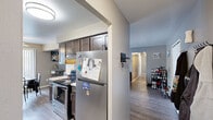 Located at 27435 Greenfield Rd in Southfield, Michigan, this single-floor unit offers a practical and well-organized layout featuring one bedroom, three bathrooms, a living room, a kitchen, and two hallways. The open living room is generously proportioned, featuring light wood-look flooring, neutral gray walls, and large windows with vertical blinds that allow natural light to fill the space. The room flows seamlessly toward the dining area, which is enhanced by a ceiling fan and an additional window overlooking the outdoors. The galley-style kitchen is a functional highlight, equipped with dark wood cabinetry, light stone-patterned countertops, stainless steel appliances including a range and refrigerator, a double-basin sink, and a built-in dishwasher. The spacious primary bedroom features plush carpeting, neutral tones, and a large window with vertical blinds offering outdoor views. The three bathrooms are well-appointed, each featuring warm-toned walls and wood-cabinet vanities with light stone countertops. Two bathrooms include wide vanity mirrors with overhead lighting, while one features a shower-tub combination. Two connecting hallways efficiently link all areas of the unit, contributing to a cohesive and navigable floor plan throughout.