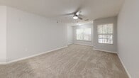 Located at 304 Buck Island Rd in Bluffton, SC, this single-floor, 2-bedroom, 1-bathroom residence offers a well-organized layout designed for comfortable everyday living. The interior is finished in a consistent neutral palette of soft grays and whites, creating a clean, cohesive aesthetic throughout.

The kitchen is efficiently designed with white shaker-style cabinetry, stainless steel appliances including a refrigerator, range, and over-the-range microwave, and light wood-look flooring that extends into the hallway. The open layout connects the kitchen to the living area, which features plush carpeting and a ceiling fan with light fixture.

The spacious primary bedroom is a standout feature, offering generous square footage, plush carpet flooring, a ceiling fan, a walk-in closet, and multiple windows that invite natural light and views of surrounding greenery. The second bedroom is comparably well-lit, with carpet flooring, a ceiling fan, and windows on two walls providing ample natural light.

The bathroom is finished with wood-look tile flooring, white cabinetry with dark countertops, brushed nickel hardware, and a full tub-shower combination with clean white surround panels.