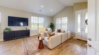 Located at 100 Big River Dr in Lake Saint Louis, Missouri, this well-appointed single-story home offers three bedrooms, three bathrooms, a dedicated office, and an attached garage. The open-concept kitchen and living area serves as the heart of the home, featuring soaring vaulted ceilings, recessed lighting, and large windows that fill the space with natural light. The kitchen is equipped with white shaker cabinetry, granite countertops, stainless steel appliances including a range with a wall-mounted hood, and a generous island with bar seating beneath stylish pendant lights. The living room flows seamlessly from the kitchen, showcasing hardwood-style flooring and ample room for entertaining. The primary bedroom includes a spacious walk-in closet with wire shelving systems and carpet flooring. Secondary bedrooms are comfortably sized with carpet flooring, ceiling fans, and natural light. The dedicated office provides a quiet workspace, while the laundry room is outfitted with a full-size Whirlpool washer and dryer with overhead shelving. Three full bathrooms feature neutral finishes throughout. The attached garage includes parking bumpers and interior access. Outside, a well-maintained lawn extends across an open, rolling landscape with expansive sky views.