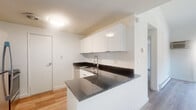 Located at 170 Southwind Dr in Wallingford, CT, this two-bedroom, one-bathroom residence offers a thoughtfully designed single-floor layout with a clean, modern aesthetic throughout. Light wood-tone flooring runs continuously across all rooms, creating a cohesive and welcoming feel.

The kitchen is a standout feature, equipped with sleek white cabinetry, dark granite countertops, stainless steel appliances including a refrigerator and range, and a peninsula that provides additional prep and serving space. The open layout allows for a natural flow into the adjacent living area.

The living room is bright and airy, benefiting from a sliding glass door that opens to a balcony, allowing an abundance of natural light to fill the space. Baseboard heating is present throughout the unit for efficient climate control.

The primary bedroom is generously sized, featuring a large bifold closet and direct access to the balcony. The second bedroom offers a comfortable layout with a window framing views of the surrounding greenery and its own baseboard heating. Both bedrooms feature the same light wood flooring found throughout the home.

The bathroom is clean and functional, appointed with white cabinetry, a full tub-shower combination, and warm wood flooring. Two hallways connect the rooms efficiently, completing this well-organized and move-in ready residence.