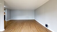 Located at 3506 Silver Park Ct in Suitland, MD, this single-floor residence offers four bedrooms, three bathrooms, and a well-considered layout designed for comfortable living. The combined kitchen and living area serves as the heart of the home, featuring warm hardwood-style flooring throughout. The kitchen is thoughtfully appointed with white shaker cabinetry, dark granite countertops, a stainless steel sink, a gas range, and a full-size refrigerator. An open shelving pantry area adds practical storage. The living area is bright and clean with neutral gray walls and crisp white baseboards. A central hallway connects the main living spaces to the four bedrooms, which feature plush carpeting and large windows that invite natural light and offer views of surrounding greenery. The generously sized primary bedroom provides ample space. The three bathrooms are finished with marble-style tilework, granite-topped vanities with dark wood cabinetry, and a sleek glass shower enclosure with marble-look tile surround. Two dedicated closets provide additional storage throughout. The space presents a clean, updated aesthetic with a neutral palette, making it a versatile and move-in ready home.