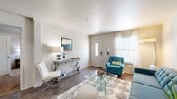This single-floor, 2-bedroom, 2-bathroom residence offers a thoughtfully designed layout that maximizes functionality and comfort. The living room serves as the welcoming heart of the home, featuring durable wood-style flooring, a textured ceiling, and natural light streaming through large windows fitted with blinds and sheer curtains. The front entry door with a sidelight panel adds an inviting touch to the space.

The galley-style kitchen is efficiently organized with white upper cabinetry, gray lower cabinets, white countertops, and a classic subway tile backsplash. Black appliances, including a refrigerator, electric range, microwave, and dishwasher, complement the clean, modern aesthetic, while wood-style flooring ties the space together seamlessly.

Both bedrooms are carpeted and bright, each benefiting from natural light through sizable windows with blinds and curtains. The primary bedroom offers a generous footprint with ample room for furnishings. Two closets throughout the unit provide dedicated storage space, with walk-in shelving for organized storage.

The bathrooms feature wood-style flooring, vanities with white cabinetry, and tub-shower combinations with tiled surrounds. A dedicated laundry area adds everyday convenience, rounding out this well-equipped and comfortable residence.