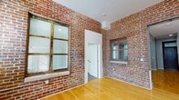 This contemporary apartment, located at 306 South 15th Street in downtown Omaha, offers a perfect blend of modern amenities and industrial charm. The 940 square foot space is efficiently designed with three bedrooms and two bathrooms, including a generous 230 square foot primary bedroom. The open-concept living area showcases exposed brick walls, adding character and warmth to the space. Gleaming hardwood floors run throughout the main living areas, while plush carpeting in the bedrooms ensures comfort underfoot.

The kitchen is a highlight, featuring white cabinetry, granite countertops, and stainless steel appliances. A subway tile backsplash and ample counter space make it both stylish and functional. The bathrooms are tastefully appointed with large vanities, modern fixtures, and a combination of tiled and carpeted flooring.

Large windows in the bedrooms and living areas allow for plenty of natural light, while providing views of the vibrant downtown area. The apartment's neutral color palette provides a blank canvas for personal style. With its prime location and thoughtful design, this apartment offers the perfect balance of urban living and home comfort.
