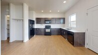Located in Bluffdale, Utah, this three-bedroom, one-bathroom home is spread across three floors, offering a well-organized layout with generous living space throughout. The main level features an open-concept kitchen, dining, and living area filled with natural light from well-placed windows. The kitchen is appointed with dark espresso-toned cabinetry, light countertops, black appliances including a refrigerator, range, microwave, and dishwasher, and light hardwood-style flooring that flows seamlessly throughout the common areas. The living spaces are bright and airy, with clean white walls and recessed lighting adding to the modern, understated aesthetic. The three bedrooms are carpeted for comfort, with several rooms featuring multiple windows that invite natural light and neighborhood views. The primary bedroom is generously sized and includes access to a spacious walk-in closet outfitted with built-in shelving and dual hanging rods. The bathroom features a full tub-shower combination with white tile surround. Additional highlights include five closets for exceptional storage, two utility rooms, a balcony, and an unfinished lower level with significant potential. Four staircases connect the floors, making the home highly accessible throughout.