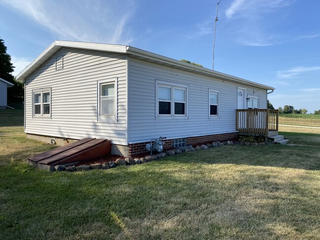 Side of house with basement access. Some shelving down there and room for storage. - W4493 Spruce Dr