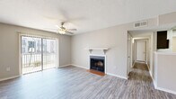 Located at 221 Eisenhower Dr in Biloxi, Mississippi, this single-floor, 2-bedroom, 2-bathroom residence offers a functional and well-appointed layout. The living room serves as the heart of the home, featuring a classic fireplace with a white mantel and terra cotta tile hearth, a ceiling fan, and a sliding glass door with vertical blinds that invites natural light and outdoor access. Wood-look luxury vinyl flooring extends consistently throughout the space, providing a clean, cohesive aesthetic.

The galley-style kitchen is efficiently designed with dark cabinetry, granite-style countertops, a white subway tile backsplash, a skylight, stainless steel appliances, and a deep single-basin sink — offering ample storage and prep space.

Both bedrooms are comfortably proportioned, each equipped with ceiling fans and closets. The primary bedroom provides a generous amount of space, while the second bedroom features a distinctive navy blue accent wall for added character. The bathrooms include one with a full tub-and-shower combination clad in crisp white subway tile, and another featuring a wide vanity with a granite-style countertop and dark cabinetry. Additional amenities include a dedicated laundry area and utility room, completing this well-rounded home.