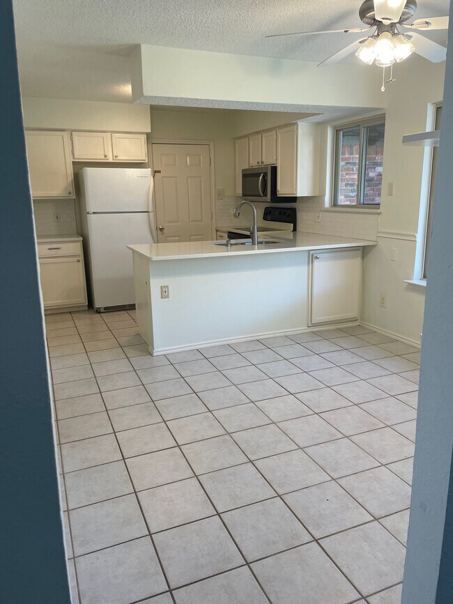 Eat in kitchen with bar overhang sitting area and bonus cabinet. - 125 Cherrybark Dr