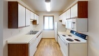 This single-floor unit at 1830 49th St S in Fargo, North Dakota offers a practical and well-organized layout designed for comfortable everyday living. The open entry area flows directly into a combined kitchen and living space, where light wood-style flooring creates a cohesive, clean aesthetic throughout. A ceiling fan overhead adds both comfort and character to this shared zone.

The galley-style kitchen is efficiently designed, featuring white cabinetry on both sides, ample upper and lower storage, a double basin sink, white appliances including an electric range, dishwasher, refrigerator, and microwave, and a window that allows natural light to brighten the workspace.

The living area is generously proportioned, with plush carpeting, a textured ceiling, baseboard heating, and a sliding glass door that opens to an outdoor view, providing an airy, connected feel.

The bedrooms are carpeted and well-lit, each with a window featuring blinds, baseboard heating, and ceiling fixtures. One bedroom includes a ceiling fan for added airflow. The full bathroom is finished with wood-tone cabinetry, a single-sink vanity with a large mirror, a soaking tub with shower, and wood-style flooring, rounding out this straightforward and functional space.