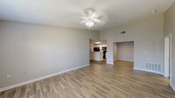 This single-floor residence at 2931 Barker Cypress Rd in Houston, Texas offers a well-organized layout with a clean, neutral aesthetic throughout. The open living area features wood-look plank flooring, light gray walls, and a ceiling fan with integrated lighting, creating a bright and functional space. Natural light enters through windows fitted with blinds, adding to the airy atmosphere. A second living or dining area flows seamlessly from the main living space, sharing the same flooring and easy access to the kitchen.

The kitchen is equipped with white cabinetry, white countertops, a stainless sink, and a full suite of black appliances including a refrigerator, electric range, and over-the-range microwave. A peninsula-style breakfast bar connects the kitchen to the living area, enhancing the open feel.

The bedrooms feature plush carpeting, ceiling fans with lighting, and windows that allow natural light in. A spacious walk-in closet with wire shelving provides ample storage. Additional flexible space with wood-look flooring can serve as a dining room, office, or den.

The bathrooms are finished with wood-look tile flooring, white cabinetry, and tub/shower combinations with clean white surrounds. Overall, the space presents a practical, move-in-ready layout suited for comfortable everyday living.