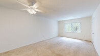 Located at 6551 Gulf Gate Place in Sarasota, Florida, this two-bedroom, one-bathroom residence offers a straightforward single-floor layout designed for comfortable everyday living. The floor plan connects the main living areas efficiently through two hallways, providing a logical flow throughout the home.

The generously sized primary bedroom features soft wall-to-wall carpeting, a ceiling fan with light fixture, and a large window fitted with vertical blinds that allow natural light to filter in. The second bedroom is equally well-appointed, also featuring plush carpeting and a large window with vertical blinds offering outdoor views, along with a louvered bifold closet door for ample storage.

The kitchen is bright and functional, showcasing white cabinetry with modern hardware, light countertops, wood-look luxury vinyl plank flooring, and a full suite of white appliances including an electric range and refrigerator. A window above the kitchen area brings in additional natural light, enhancing the clean, open feel of the space.

The bathroom maintains a crisp, clean aesthetic with white tile flooring, a white vanity with under-cabinet storage, a large mirror with overhead lighting, and a shower-tub combination. The neutral white palette throughout the home creates a bright, airy ambiance that feels open and easy to personalize.