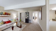 Located at 2401 W Broadway in Columbia, Missouri, this single-floor, 2-bedroom, 1-bathroom unit offers a well-organized layout across a comfortable footprint. The living room serves as the heart of the home, featuring warm neutral-toned carpet, a distinctive accent wall with vertical wood paneling, and a vaulted ceiling detail that lends an open, airy feel. Natural light filters in through a window near the entryway, enhancing the welcoming ambiance. An in-room closet provides convenient additional storage directly off the living space.

The adjacent dining area transitions seamlessly from the living room, featuring tile flooring and a cozy, defined space ideal for meals and gatherings. The galley-style kitchen is efficiently designed with ample cabinetry, dark countertops, tile flooring, and includes a full suite of appliances — electric range, refrigerator, and dishwasher.

Both bedrooms are carpeted and feature ceiling fans and windows that allow natural light to brighten each room. The primary bedroom is generously sized and includes access to a dedicated walk-in closet with multi-tiered shelving and hanging rods. The full bathroom includes a tiled shower-tub combination and standard fixtures. A hallway connects all rooms, ensuring a logical and functional flow throughout the unit.