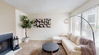 Located at 6001 E Pima St in Tucson, AZ, this 2-bedroom, 2-bathroom unit delivers a practical and well-organized single-floor layout. The living room features plush carpeting, a large window that fills the space with natural light, and a tiled entryway near the front door. Adjacent to it, a second flexible room with carpet flooring offers additional living space. The dining area connects seamlessly to the kitchen, which is equipped with oak cabinetry, white appliances including a refrigerator and electric range, a built-in microwave, and wood-style flooring. A ceiling fan overhead and a built-in shelving unit nearby add both function and character to the dining space. The primary bedroom is a comfortable retreat, featuring soft carpet, a sage-green accent wall, sliding glass doors that open to an outdoor patio, and a mirrored closet. A dedicated vanity area with a wood-trimmed countertop provides additional convenience. The bathrooms are clean and functional, with wood-style flooring, a shower/tub combination, and warm-toned wood vanities. Throughout the unit, neutral walls and consistent finishes create a cohesive, understated aesthetic well-suited to Tucson living.