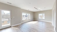 This well-appointed 1-bedroom, 1-bathroom unit offers a thoughtfully designed single-floor layout that maximizes functionality and comfort. Light hardwood flooring flows consistently throughout the space, complemented by neutral warm-gray walls and crisp white trim, creating a clean, contemporary aesthetic.

The open-concept kitchen and living area serves as the heart of the unit. The kitchen features rich dark-espresso cabinetry, granite countertops, and a full suite of stainless steel appliances, including a French door refrigerator with ice maker, electric range, and built-in microwave. A peninsula with granite countertop and an undermount sink provides additional prep space and casual seating. An adjacent open pantry with wire shelving adds practical storage.

The living area is generously sized, benefiting from multiple large windows that flood the room with natural light and offer views of the surrounding neighborhood and cityscape. Track lighting provides additional illumination overhead.

The bedroom is a comfortable, private retreat with its own large window framing outdoor views and ample wall space for furnishings. The full bathroom is finished with large-format gray tile on both the floor and tub surround, a dark-cabinetry vanity with granite countertop, undermount sink, and a tub-shower combination. A dedicated closet completes the unit's storage offerings.