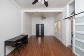 Located at 701 Seventh Avenue in downtown San Diego, this studio unit offers a well-organized and efficiently designed living space across a single floor. The main living area features warm hardwood flooring, crisp white walls, and dual ceiling fans that contribute to a bright and airy atmosphere. Exposed structural beams add a subtle industrial character, while a window allows natural light to filter in, enhancing the open feel of the room. A closet provides dedicated storage within the living space.

The kitchen is compact and practical, outfitted with light tile flooring, a stainless steel refrigerator, and a wooden-topped storage unit that doubles as a prep surface, making efficient use of the available footprint.

The bathroom stands out as a recently updated highlight of the unit. It features marble-look tile walls in the walk-in glass shower, a clean white vanity with a mirror, light tile flooring, and modern vanity lighting — delivering a polished, contemporary aesthetic. A frosted sliding barn-style door adds a stylish and space-conscious entry to the bathroom.

Overall, this studio presents a clean, functional layout with thoughtful finishes, situated in a prime downtown San Diego location with easy access to the city's dining, entertainment, and transit corridors.