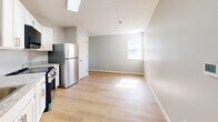 Located at 600 Sherman St in Akron, Ohio, this single-floor, 2-bedroom, 1-bathroom unit offers a clean and efficiently designed living space with a consistent, modern aesthetic throughout. Light hardwood-style flooring runs continuously across all rooms, complemented by soft gray walls and crisp white trim, creating a bright and cohesive interior.

The open living and kitchen area is anchored by a well-appointed kitchen featuring white shaker-style cabinetry, granite-look countertops, a stainless steel refrigerator, range, and built-in microwave. A skylight overhead floods the kitchen with natural light, enhancing the airy feel of the space.

Both bedrooms are modestly sized, with the primary bedroom offering a closet and windows that allow natural light and neighborhood views. The second bedroom also includes a closet and window. Each room reflects the same neutral palette and clean finishes found throughout the unit.

The bathroom is neatly finished with a white vanity, a tub and shower combo, and matching light flooring. A utility panel is accessible from the main living area. Overall, the space presents a straightforward, move-in-ready layout with updated finishes, making it a practical and functional living option in Akron.
