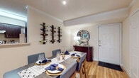 This single-floor residence offers a thoughtfully designed layout that balances comfort and functionality across several well-defined living spaces. Light-toned walls and warm hardwood-style flooring run throughout the main living areas, creating a cohesive and inviting atmosphere.

The dining area serves as a welcoming entry point, featuring wall-mounted wine racks, crown molding, and a sideboard topped with a decorative round mirror. The space flows openly toward a hallway accented with a macramé wall hanging and artwork.

The galley-style kitchen is equipped with dark espresso cabinetry, granite-look countertops, and stainless steel appliances, including a full-size refrigerator and dishwasher. Hardwood-style flooring continues here, adding warmth to the functional layout.

The living room is bright and open, with a ceiling fan, crown molding, and sliding glass doors that invite natural light and provide access to a private outdoor area. The space connects visibly to the bedroom wing.

Multiple bedrooms feature plush carpeting, ceiling fans, and generous windows with blinds that allow for adjustable natural light. The bathrooms include wood-toned vanities with granite-look countertops, large mirrors, and hardwood-style flooring.