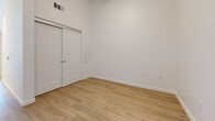 Located on the fifth floor at 615 E Carson St in Carson, California, Unit #512 is a thoughtfully designed studio that makes efficient use of its space. The open-plan layout seamlessly connects the kitchen and living area, creating a bright and cohesive environment finished with light wood-style flooring and crisp white walls throughout.

The kitchen is well-appointed with white flat-front cabinetry, dark countertops, and a classic subway tile backsplash. Stainless steel appliances — including a range, over-the-range microwave, and dishwasher — provide a modern, functional cooking space. Under-cabinet lighting adds both utility and ambiance, while a ceiling fan overhead keeps the living area comfortable and airy.

The living area is clean and open, bathed in natural light from a window that offers views to the outside. The neutral palette and uncluttered design lend the space a calm, contemporary feel.

The bathroom is finished with the same cohesive aesthetic, featuring white cabinetry, a dark countertop vanity with an undermount sink, a large mirror, and a full tub-shower combination with built-in shelving. Wood-style flooring continues into this space, tying the unit together.

A sliding-door closet provides convenient storage, completing this modern, move-in-ready unit.