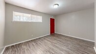 This 550 square foot apartment, located at 2219 Dauphin Island Pkwy in Mobile, Alabama, offers a well-designed living space on a single floor. The layout comprises a spacious 190 square foot bedroom, a full bathroom, and an open-concept kitchen and living area.

The interior is characterized by modern finishes, with wood-look flooring throughout that adds warmth and visual continuity to the space. The kitchen features white cabinetry with ample storage, contrasting dark countertops, and updated stainless steel appliances, including a refrigerator and electric range. A double sink and overhead lighting complete the functional cooking area.

The living room, while compact, offers flexibility for furniture arrangement and is brightened by natural light from windows. The bedroom, sizeable at 190 square feet, includes closet space and a window for natural illumination. The bathroom is efficiently designed with a white tub-shower combination, toilet, and vanity, maintaining a clean and bright aesthetic.

Noteworthy elements include the crisp white walls throughout, providing a neutral backdrop for personalization, and the striking red front door that adds a pop of color to the exterior. Ceiling-mounted light fixtures in the main living areas ensure adequate illumination.

This apartment combines modern amenities with a practical layout, making efficient use of its 550 square feet to create a comfortable living environment suitable for a single occupant or couple.