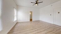 Located at 323 E Lomita Ave in Glendale, California, this efficiently designed single-floor unit offers a clean, modern aesthetic throughout. Light wood-tone laminate flooring runs consistently across all rooms, creating a cohesive and airy feel.

The living room is the heart of the unit, featuring crisp white walls, a ceiling fan with integrated lighting, and windows fitted with white blinds that invite natural light while maintaining privacy. The open, uncluttered layout maximizes the available space and allows for flexible furniture arrangements.

The kitchen is thoughtfully equipped with white shaker-style cabinetry, dark countertops, and a full suite of stainless steel appliances — including a refrigerator, gas range, and microwave — providing a functional and contemporary cooking environment. The matching flooring carries through seamlessly from the living area.

A hallway connects the main living space to the bathroom, which continues the bright, white palette. The bathroom includes a vanity with an undermount sink, a mirror, a bathtub, and a window that brings in natural light — all finished in a clean, minimalist style.

The overall ambiance of this Glendale unit is fresh and modern, with consistent finishes and a well-organized layout that makes efficient use of every square foot.