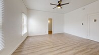 Located at 323 E Lomita Ave in Glendale, California, this efficiently designed single-floor unit offers a clean, modern aesthetic throughout. Light wood-tone laminate flooring runs consistently across all rooms, creating a cohesive and airy feel.

The living room is the heart of the unit, featuring crisp white walls, a ceiling fan with integrated lighting, and windows fitted with white blinds that invite natural light while maintaining privacy. The open, uncluttered layout maximizes the available space and allows for flexible furniture arrangements.

The kitchen is thoughtfully equipped with white shaker-style cabinetry, dark countertops, and a full suite of stainless steel appliances — including a refrigerator, gas range, and microwave — providing a functional and contemporary cooking environment. The matching flooring carries through seamlessly from the living area.

A hallway connects the main living space to the bathroom, which continues the bright, white palette. The bathroom includes a vanity with an undermount sink, a mirror, a bathtub, and a window that brings in natural light — all finished in a clean, minimalist style.

The overall ambiance of this Glendale unit is fresh and modern, with consistent finishes and a well-organized layout that makes efficient use of every square foot.