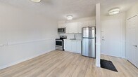 Located at 1050 Highland St in Burlington, Ontario, Unit 4 is a thoughtfully laid-out one-bedroom, one-bathroom unit situated on a single floor. Light-toned hardwood-style flooring runs throughout, lending a clean and cohesive look to the space.

The combined dining and living area is generously proportioned, featuring multiple windows that bring in natural light and offer views of the surrounding outdoor greenery. A textured ceiling adds subtle character to this main living space, which also includes baseboard heating.

The kitchen is efficiently designed with crisp white cabinetry, a stainless steel undermount sink, light-toned countertops, and a full suite of stainless steel appliances including a refrigerator, electric range, and microwave. The layout makes smart use of the available space.

The bedroom is a comfortable, quiet retreat with its own window overlooking the outdoors and baseboard heating. It features two closets with classic panel doors, offering practical storage solutions. The bathroom is clean and functional, appointed with a full-sized tiled tub-shower surround and modern fixtures.

The unit also includes a dedicated entrance and additional unclassified space, rounding out a practical and move-in-ready layout ideal for individuals or couples seeking a manageable, low-maintenance home in Burlington.