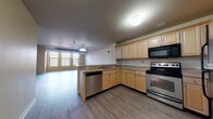 Located in Hartford, CT, this single-floor residence offers a thoughtfully designed open-concept layout that promotes a seamless flow between the living and kitchen areas. The living room is generously sized, bathed in natural light through large multi-pane windows, and finished with durable wood-look flooring that extends throughout the main living spaces. A pendant light fixture adds a welcoming touch overhead.

The kitchen is both functional and well-equipped, featuring light maple cabinetry with ample storage, neutral laminate countertops, and a suite of stainless steel appliances including an electric range, built-in microwave, dishwasher, and refrigerator. A peninsula provides additional counter space and serves as a natural divider between the kitchen and living area.

The bedroom is carpeted for comfort and features notably tall ceilings, a large window for natural light, and direct access to a dedicated walk-in closet with built-in shelving. The bathroom includes a wide vanity with a large mirror, wood-toned cabinetry, and tile-style flooring.

A dedicated in-unit laundry area houses a full-size washer and dryer with overhead wire shelving for added storage convenience. The overall aesthetic is clean, neutral, and move-in ready.
