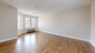 Located on S Colfax Ave in Chicago's South Side, this 2-bedroom, 1-bathroom unit offers a well-organized single-floor layout that balances classic Chicago architecture with modern updates. Rich hardwood flooring flows throughout the main living areas and bedrooms, adding warmth and character to the space. The living room is generously sized, featuring a cast-iron radiator, neutral walls, and a window that draws in natural light. Both bedrooms are comfortably proportioned — the primary bedroom includes a closet and windows overlooking the surrounding neighborhood, while the second bedroom also features a radiator and its own window, maintaining a consistent, cozy feel. The kitchen has been thoughtfully updated with white shaker-style cabinetry, granite-look countertops, light vinyl plank flooring, and a full suite of stainless steel appliances including a gas range, microwave, and refrigerator. A window above the range area adds brightness to the cooking space. The bathroom features tile flooring, a tub-shower combo with tiled surround, a vanity with storage, and a glass block window for privacy and light. Multiple hallways connect the rooms efficiently, and the overall layout makes excellent use of the available space throughout.