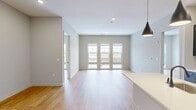 This contemporary apartment, located at 51 Okner Pkwy in Livington, NJ, offers 1180 square feet of thoughtfully designed living space. The single-story floor plan includes two bedrooms, two bathrooms, and an open-concept living area. The primary bedroom is generously sized at 190 square feet, providing ample space for relaxation.

The heart of the home is the modern kitchen, featuring sleek dark cabinetry, stainless steel appliances, and a stylish subway tile backsplash. A central island with a built-in sink adds functionality and serves as a casual dining area. The adjacent living room boasts large windows that flood the space with natural light, creating an airy and inviting atmosphere.

Both bathrooms showcase a clean, modern aesthetic with marble-look flooring, dark vanities, and chrome fixtures. The apartment's bedrooms are well-proportioned, with the second bedroom offering flexibility as a guest room or home office. Built-in closets provide ample storage throughout.

Light wood-toned flooring unifies the space, complementing the neutral wall colors and adding warmth to the overall design. Recessed lighting and contemporary pendant fixtures enhance the modern ambiance. This thoughtfully designed apartment combines style and functionality, perfect for comfortable urban living.