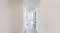 This 2-bedroom, 2-bathroom apartment in Beaverton, Oregon offers a clean, modern aesthetic throughout its thoughtfully designed single-floor layout. The open-concept living and kitchen area is anchored by light wood-style flooring and crisp white walls, creating a bright and airy atmosphere. The kitchen is outfitted with contemporary two-tone cabinetry in white and warm wood tones, quartz-style countertops, stainless steel appliances including a refrigerator, stove, and microwave, an undermount sink with a gooseneck faucet, and a white subway tile backsplash with floating wood shelving. The living area features multiple large windows that flood the space with natural light and frame sweeping views of the Beaverton skyline and surrounding greenery, with access to a private balcony. Both bedrooms are comfortably sized with light flooring, generous closet space, and windows offering outdoor views. The primary bedroom includes a dedicated closet area. Each bathroom is finished with wood-look flooring, a tub-shower combination with chrome fixtures, and a vanity with storage. The overall ambiance is modern, clean, and move-in ready, ideal for those seeking a well-appointed home in the Pacific Northwest.