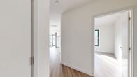 Located at 125 South Harrison Street in East Orange, NJ, this thoughtfully designed 2-bedroom, 1-bathroom unit offers a clean, modern aesthetic throughout. Wide-plank hardwood-style flooring runs continuously across the entire floor plan, creating a cohesive and contemporary feel.

The open-concept kitchen and living area serves as the heart of the unit. The kitchen is outfitted with stainless steel appliances — including a full-size refrigerator, electric range, microwave, and dishwasher — complemented by two-tone cabinetry featuring white upper cabinets and natural wood-finish lower cabinets, a subway tile backsplash, and light stone countertops. A window above the kitchen provides natural light to the space.

The living area benefits from large, black-framed sliding glass doors that offer views of the surrounding neighborhood and fill the room with abundant natural light. Both bedrooms are well-proportioned, bright, and feature windows with natural light. The primary bedroom is a comfortable size and includes access to closet space. With four closets total, storage is plentiful throughout the unit.

The bathroom is finished in a crisp, all-white palette with marble-style tile flooring, a floating vanity with a mirrored medicine cabinet, and brushed bronze fixtures. A utility room and hallway complete the layout, adding practicality to this well-appointed home.