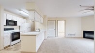 Located at 482 Crestmont Ct in Copley, Ohio, this single-floor unit offers a practical and comfortable layout designed for easy living. The open-concept kitchen flows seamlessly into the main living area, creating a connected and functional space. The kitchen features white cabinetry, a peninsula with a built-in sink, white appliances including a refrigerator and range, and an over-the-range microwave. Ample upper cabinet storage and under-counter space provide excellent organization.

The living area is generously proportioned, with soft carpeting throughout and a ceiling fan overhead. Neutral, light-toned walls contribute to a bright and airy atmosphere. The entry foyer includes tile flooring and a closet, offering a welcoming transition into the main space.

The bedrooms are well-sized, each featuring plush carpeting and windows fitted with blinds that allow natural light while maintaining privacy. Views of the surrounding neighborhood greenery are visible from the windows, adding a pleasant outdoor connection.

The bathroom is clean and functional, featuring tile flooring, a full tub-shower combination with a grab bar, a toilet, and a single-sink vanity. A louvered closet door in the hallway provides convenient additional storage. The unit is served by baseboard heating and ceiling ventilation throughout.