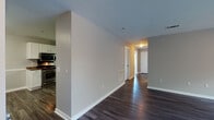 This single-floor residence offers a thoughtfully designed layout with consistent finishes throughout. The main living and hallway areas feature rich, dark hardwood-style flooring that flows seamlessly through the open floor plan, complemented by neutral gray walls and clean white trim. A ceiling fan with integrated lighting in the living area provides both comfort and illumination, while a large window invites natural light and outdoor views.

The kitchen is well-equipped with white shaker-style cabinetry, dark granite-look countertops, a double stainless steel sink, and stainless steel appliances including a range and dishwasher. Under-cabinet lighting enhances both functionality and ambiance.

The bedrooms are carpeted for comfort, each featuring ceiling fans and windows that bring in natural light. One bedroom includes direct access to an en-suite bathroom, offering added privacy and convenience. The bathrooms are finished in white, with one featuring a soaking tub and tiled surround with built-in shelving, and another with a tub-shower combination. Additional storage is provided via closet space accessible from the bathroom.

Overall, the space presents a clean, move-in-ready aesthetic with practical finishes and a functional single-level layout suited for everyday living.
