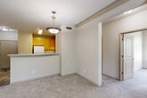 This single-floor, 3-bedroom, 2-bathroom residence offers a thoughtfully designed layout with a comfortable and practical living environment. The open-concept living and dining area features plush carpeting, a ceiling fan, and natural light streaming through French doors that lead to the outdoors, creating a bright and welcoming atmosphere.

The kitchen is efficiently designed with warm honey-toned cabinetry, granite-style countertops, a breakfast bar peninsula, and a full suite of white appliances including a refrigerator, electric range, and dishwasher. Wood-look flooring ties the kitchen into the living space seamlessly.

The generously sized primary bedroom benefits from multiple windows, a ceiling fan, and soft carpeting, while additional bedrooms are also well-lit with multiple windows and ceiling fans. Each bedroom is complemented by dedicated closet space, including a walk-in closet outfitted with wire shelving for organized storage.

The bathrooms feature wood-look flooring, warm wood cabinetry, granite-style countertops, and a tub-shower combination. Two hallways connect the private and shared areas of the home, adding to the overall flow of the floorplan. Throughout the residence, a neutral color palette and consistent finishes create a cohesive and inviting ambiance.
