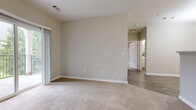 This single-floor residence offers a thoughtfully designed layout with a neutral color palette and a blend of carpet and wood-look flooring throughout. The kitchen is a standout feature, equipped with stainless steel appliances—including a gas range, microwave, and refrigerator—paired with white cabinetry, light stone countertops, and wood-look tile flooring. A walk-in pantry provides generous storage, complementing the kitchen's functional design. The living area is generously sized and carpeted, with a sliding glass door that opens to a private balcony overlooking a green, tree-lined setting, bringing natural light and outdoor views into the space. The bedrooms are carpeted and well-proportioned, each featuring ample closet space, including a large walk-in closet with built-in shelving and hanging rods. The bathroom is finished with wood-look tile flooring, a vanity with stone countertops, and a full tub-shower combination. A dedicated laundry area houses a full-size top-load washer and dryer. Throughout the residence, clean white trim, neutral walls, and consistent finishes contribute to a cohesive and move-in-ready atmosphere.