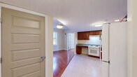 Located at 445 Zion St in Hartford, CT, this two-bedroom, one-bathroom residence offers a practical and well-appointed single-floor layout. Warm hardwood flooring flows throughout the living room and both bedrooms, creating a cohesive and inviting atmosphere, while light-colored tile grounds the kitchen and bathroom areas.

The kitchen is a functional highlight of the unit, featuring rich cherry wood cabinetry, granite countertops, a white range, and a full-size refrigerator. An accessible, open sink area with knee clearance reflects thoughtful, inclusive design. The layout provides ample cabinet storage and counter workspace.

The living room receives natural light through a window overlooking the outdoors, adding a bright and airy quality to the space. Both bedrooms continue the hardwood flooring and are served by natural light through individual windows. The primary bedroom includes a double closet with paneled doors, and the unit benefits from a total of three closets for generous storage.

The bathroom is designed with accessibility in mind, featuring a roll-in shower with grab bars and a fold-down bench, tile flooring, and a granite-topped vanity. A fire alarm system is installed throughout the unit, enhancing safety. This residence offers a clean, functional, and accessible living environment.