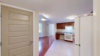 Located at 445 Zion St in Hartford, CT, this two-bedroom, one-bathroom residence offers a practical and well-appointed single-floor layout. Warm hardwood flooring flows throughout the living room and both bedrooms, creating a cohesive and inviting atmosphere, while light-colored tile grounds the kitchen and bathroom areas.

The kitchen is a functional highlight of the unit, featuring rich cherry wood cabinetry, granite countertops, a white range, and a full-size refrigerator. An accessible, open sink area with knee clearance reflects thoughtful, inclusive design. The layout provides ample cabinet storage and counter workspace.

The living room receives natural light through a window overlooking the outdoors, adding a bright and airy quality to the space. Both bedrooms continue the hardwood flooring and are served by natural light through individual windows. The primary bedroom includes a double closet with paneled doors, and the unit benefits from a total of three closets for generous storage.

The bathroom is designed with accessibility in mind, featuring a roll-in shower with grab bars and a fold-down bench, tile flooring, and a granite-topped vanity. A fire alarm system is installed throughout the unit, enhancing safety. This residence offers a clean, functional, and accessible living environment.