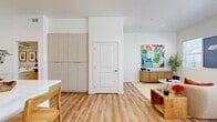 Located in Lancaster, California, this well-designed two-story home offers 4 bedrooms and 3 bathrooms across two thoughtfully laid-out floors. The ground floor hosts the main living areas, including an open-concept kitchen and living room bathed in natural light from multiple windows. The kitchen is outfitted with light wood cabinetry, a white quartz waterfall island with bar seating, stainless steel appliances, and warm wood-look vinyl plank flooring that extends throughout the home. The living area is bright and airy, featuring recessed lighting and a clean, modern aesthetic. An attached garage provides convenient direct access and additional storage space. Upstairs, the more expansive second floor accommodates all four bedrooms, including a primary bedroom with a dedicated walk-in closet. The bathrooms feature light wood vanities, white countertops, and tub-shower combinations. A dedicated laundry room houses a full-size front-loading washer and dryer. The bedrooms are well-proportioned, filled with natural light through windowed walls, and finished with the same warm flooring found throughout. Clean white walls, recessed lighting, and consistent modern finishes give the entire home a cohesive, contemporary character.
