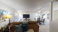 Located at 675 Alvarado Ave in Davis, California, this two-story residence offers a well-organized layout designed for comfortable everyday living. The open-concept main living area seamlessly connects the living room and dining space, creating a cohesive and functional gathering zone. Carpeted flooring runs throughout the living areas, and textured ceilings are consistent across the home. Large sliding glass doors and wide windows allow natural light to fill the space while providing views of the surrounding greenery.

The living room offers generous space for seating arrangements and includes a dedicated media wall. Adjacent to it, the dining area features a pass-through window connecting directly to the kitchen, adding convenience and an open feel. The galley-style kitchen is equipped with ample white cabinetry, dark laminate countertops, a stainless steel sink, and a dishwasher. A large window over the kitchen brings in additional natural light.

The bedrooms are comfortably sized, each featuring windows with views of lush outdoor landscaping. The bathroom includes an extended vanity with built-in cabinetry and a separate water closet. A dedicated laundry area houses a full-sized washer and dryer with overhead storage cabinetry, adding practical utility to the home.