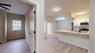 This three-bedroom, two-bathroom single-story home in Murfreesboro, Tennessee offers a clean, modern aesthetic throughout. Light-toned luxury vinyl plank flooring flows consistently across the entire floor plan, complementing the neutral wall palette and white trim that give the space a bright, cohesive feel.

The kitchen is a standout feature, showcasing white shaker cabinetry, a subway tile backsplash, quartz countertops, and a large peninsula with an undermount sink fitted with a matte black faucet. Stainless steel appliances, including a refrigerator, range, and over-the-range microwave, complete the functional and stylish setup. The kitchen opens directly to the living area, which receives natural light through a front-facing window.

The bedrooms are well-proportioned, each featuring closets with paneled doors, ceiling fans or overhead lighting, and windows with blinds that allow for natural light. The primary bedroom offers a comfortable and quiet retreat.

Both bathrooms are finished with white vanities, quartz countertops, matte black hardware, and framed mirrors. The full bathroom includes a tub/shower combo, while the primary bath features a medicine cabinet alongside the vanity mirror.

A hallway connects the bedrooms and bathrooms, and conveniently houses a stacked Whirlpool washer and dryer unit, adding practical in-unit laundry access.