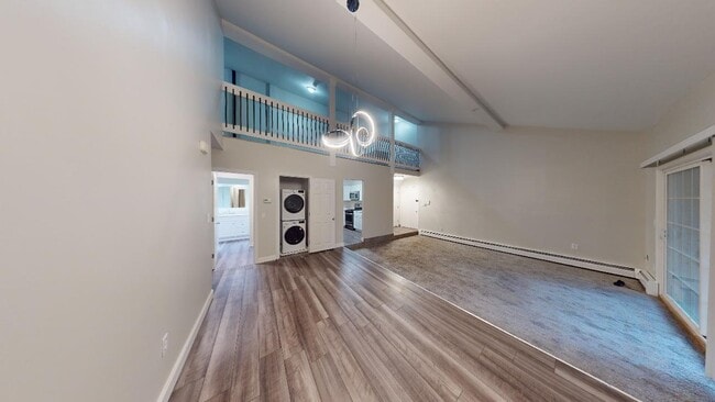Modern living room with laundry in unit, European kitchen, vaulted ceilings - Lofts & Townhomes @ International Apartments