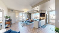 This well-appointed 2-bedroom, 2-bathroom residence at 240 Chicago Ave in Minneapolis offers a thoughtfully designed open-concept layout with modern finishes throughout. Light wood-look flooring flows seamlessly from the welcoming entry hallway into the combined kitchen and living area, creating a cohesive and airy feel.

The kitchen is a standout, featuring sleek white cabinetry, dark countertops, stainless steel appliances including a gas range and built-in microwave, a subway tile backsplash, and a peninsula with bar seating — ideal for casual dining or entertaining. The adjacent living room is bathed in natural light from large windows, offering impressive views of the Minneapolis skyline.

The primary bedroom is a comfortable retreat with a large window framing city views, and is complemented by a private en-suite bathroom featuring an illuminated mirror, white vanity with ample storage, and an organized walk-in closet. The second bedroom also enjoys generous natural light and urban views. A second full bathroom echoes the clean, modern aesthetic with white finishes and wood-look tile flooring. Additional conveniences include in-unit laundry and multiple closets for storage throughout.