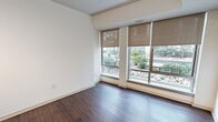 This contemporary 1-bedroom apartment, located in the WestEnd25 complex, offers a well-designed living space of 520 square feet. The open floor plan maximizes the use of space, creating a seamless flow between the living areas. Rich hardwood flooring extends throughout, adding warmth and sophistication to the interior.

The kitchen is a highlight, featuring modern stainless steel appliances, including a built-in microwave and electric stove. Granite countertops and white cabinetry provide ample workspace and storage. The living room is spacious and bright, with large windows that flood the area with natural light and offer pleasant views of the surroundings.

The bedroom, measuring 100 square feet, includes a closet with sliding doors for efficient storage. The bathroom is well-appointed with a bathtub-shower combination, a modern vanity with a granite countertop, and clean, white tiling.

Throughout the apartment, crisp white walls create a blank canvas for personalization. The unit also features modern amenities such as central air conditioning and heating, as evidenced by the visible vents. This apartment in WestEnd25 combines functionality and style, making it an ideal urban dwelling for singles or couples seeking a contemporary living space.