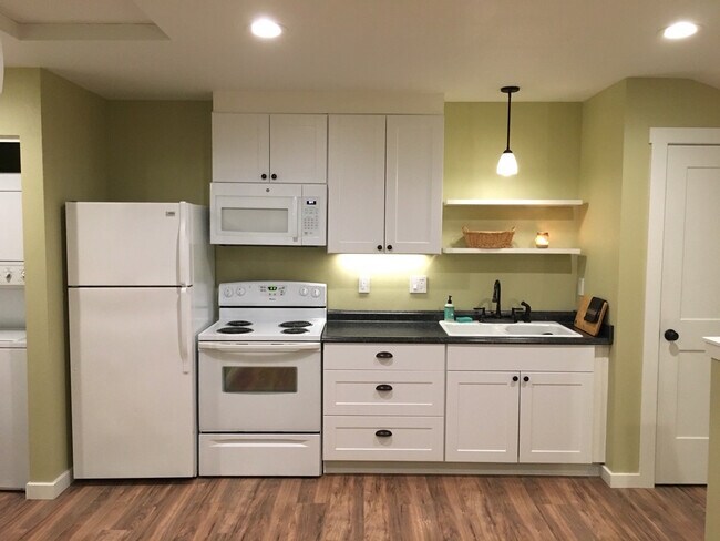 Kitchen with dishwasher, full-sized range, refrigerator, and combination microwave/oven vent. - 9235 SW 7th Ave