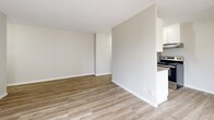 This 470 square foot apartment in London, Ontario offers a well-designed living space with modern amenities. The single-floor layout comprises a living room, one bedroom (120 sq ft), and one bathroom. Throughout the apartment, light-toned laminate flooring creates a sense of continuity and spaciousness. Large windows in the living area and bedroom allow for abundant natural light, enhancing the open feel of the space. The living room features baseboard heating and connects seamlessly to the kitchen area, separated by a partial wall for an open concept design. The bathroom boasts a full-sized bathtub with a shower, surrounded by attractive beige tiled walls and equipped with a convenient grab bar. The bedroom, while compact, offers ample space for essential furnishings. The neutral color palette of white walls and warm wood-toned flooring provides a blank canvas for personalization. This efficiently designed apartment maximizes its 470 square feet, offering a comfortable living space in an urban setting.