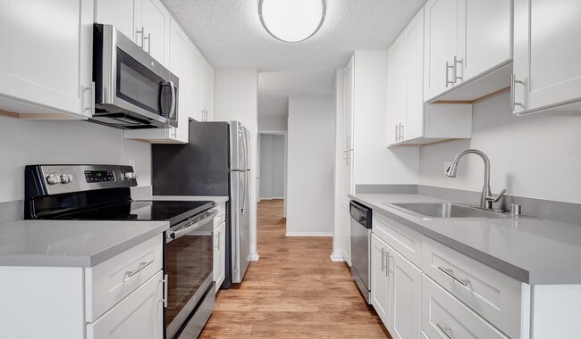 Kitchens feature stainless steel appliances and wood flooring - Laurel Crossing Apartment Homes