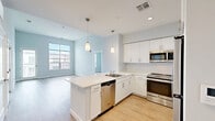 Located at 1 Crown Dr in Quincy, MA, this well-appointed 2-bedroom, 2-bathroom residence offers a thoughtfully designed single-level layout with a clean, contemporary aesthetic throughout. Light wood-style flooring flows seamlessly across the open-concept living and kitchen area, creating a bright, cohesive feel. The kitchen is equipped with stainless steel appliances, white cabinetry, a peninsula with pendant lighting, and ample counter space — ideal for everyday cooking and entertaining. The spacious living area is bathed in natural light from large windows overlooking the surrounding neighborhood.

The primary bedroom offers a generous footprint with a walk-in closet featuring wire shelving for organized storage. Both bathrooms are finished in a modern style, with wood-plank tile flooring, clean white vanities with under-cabinet storage, large mirrors, and well-lit fixtures. One bathroom includes a walk-in shower, while the second features a shower-tub combination. The second bedroom also benefits from large windows that bring in abundant natural light and exterior views.

A private balcony extends the living space outdoors, providing open views of the surrounding community and green spaces — a standout feature of this residence. The overall ambiance is fresh, neutral, and move-in ready.