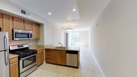 Located at 5907 Columbia in San Diego, this third-floor residence is designed with a clean, functional layout that flows naturally from room to room on a single level. The kitchen serves as a central hub, equipped with stainless steel appliances including a gas range, built-in microwave, full-size refrigerator, and dishwasher. Warm honey-toned cabinetry pairs with granite countertops, and the peninsula-style layout opens directly into the living area, which is finished with light-toned tile flooring and recessed lighting. A pendant light fixture anchors the transition between the kitchen and living space, which benefits from large windows that draw in natural light and provide views of the surrounding neighborhood.

The bedrooms offer distinct characteristics: one features light hardwood-style flooring, a large window with a neighborhood view, and bright natural light, while another includes plush carpet, a ceiling fan, and sliding glass doors that open onto a private balcony overlooking greenery. The bathroom is equipped with a combination tub and shower enclosed by sliding glass doors and includes a grab bar for added accessibility. Throughout the residence, neutral wall tones and consistent finishes contribute to a cohesive, understated aesthetic.